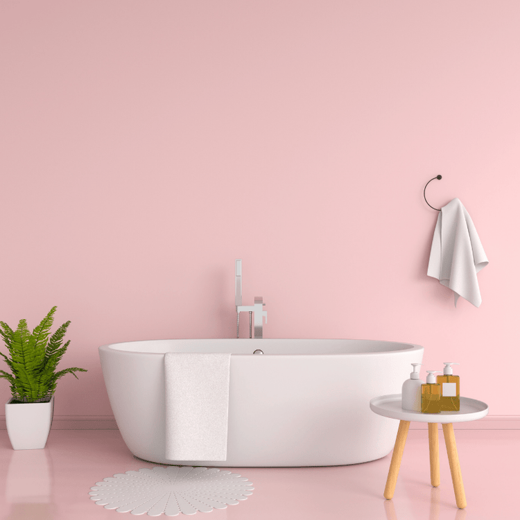 A bathtub in a pink bathroom and a stool displaying a few bath oils-Beauty & Bath - Gizmo Gifts