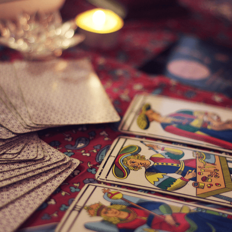 A three card tarot spread on a red tablecloth