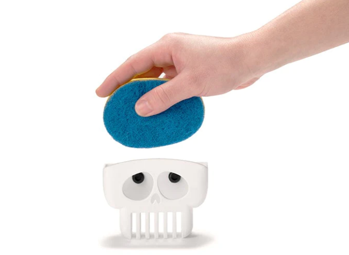 A hand lifting a blue sponge out of the brain drain sponge holder on a white background.