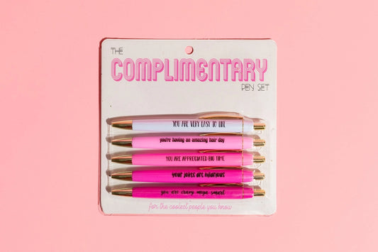Packaged set of pens with pink and gold accents on a pink background