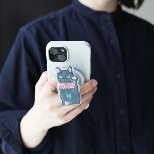 Person holding a phone with a cat-themed case against a dark background