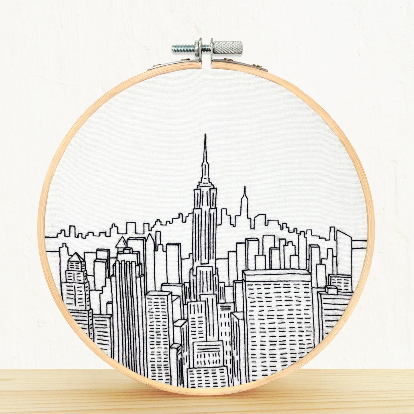 A finished example of a DIY Embroidery kit of New York City in black and white.
