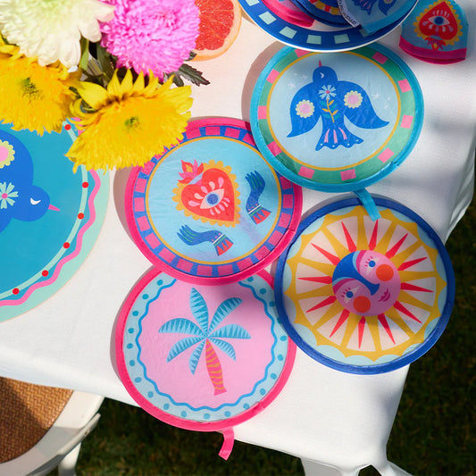 Colorful twist fans with tropical designs on a white table.