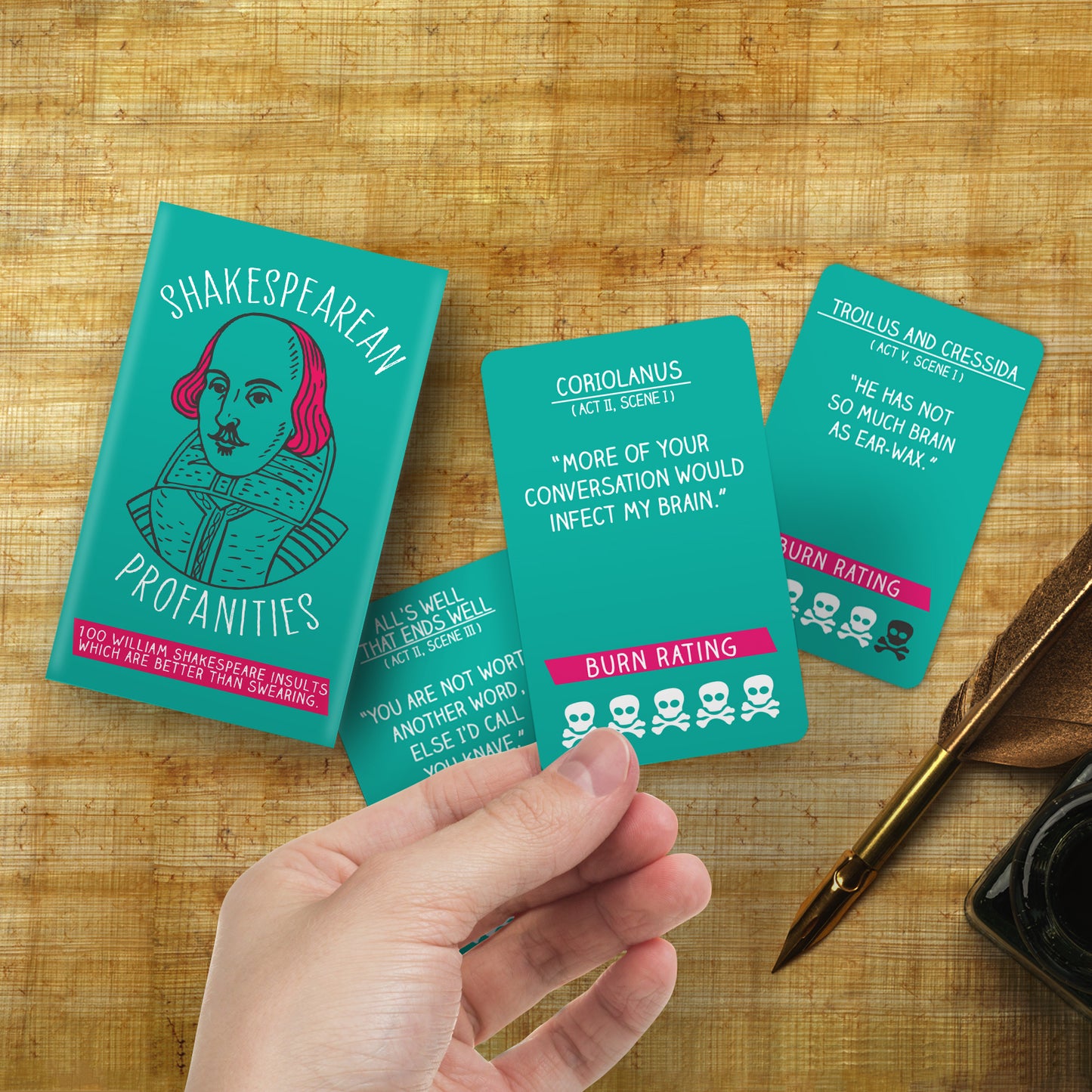 A hand showing Shakespearean Profanities cards on a brown background