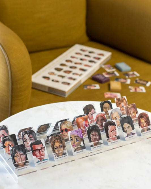 Card game with character cards on a table, with a yellow couch in the background