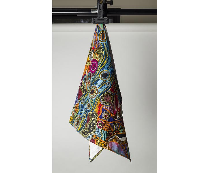 Teatowel- Australian indigenous art by Justin Butler hanging on a clip.