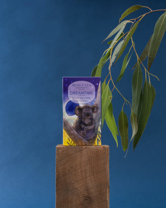 Koala Tea packaging with a koala illustration on a wooden block against a blue background