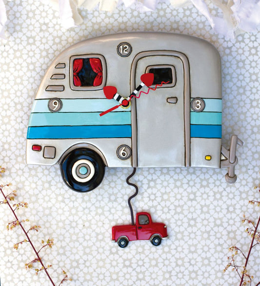 Decorative clock shaped like a camper with a red truck attached, on a textured white background.