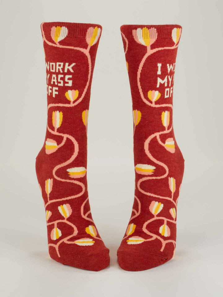 Front view of Blue Q women's crew socks featuring a brown sock and a floral arrangement pattern. The slogan on the sides reads: I work my ass off