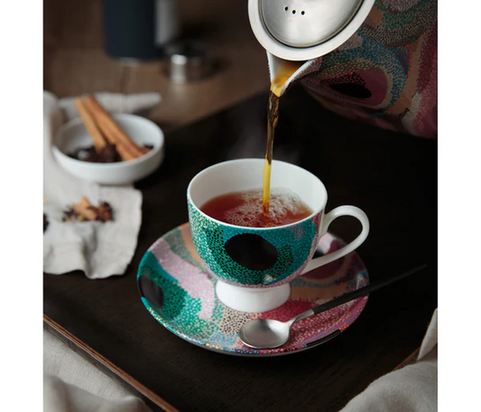 Pouring tea into a Tea cup and saucer set by indigenous artist ,Marianne Burton.