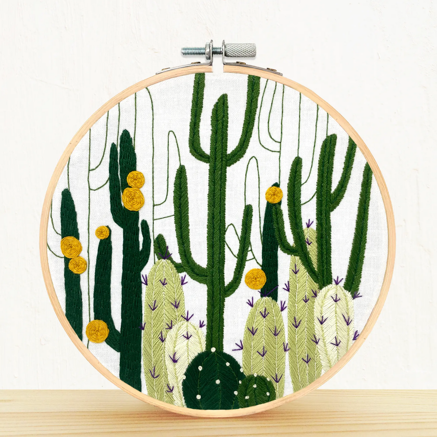 The completed embroidery loom of the cactus bloom design sitting on a shelf.