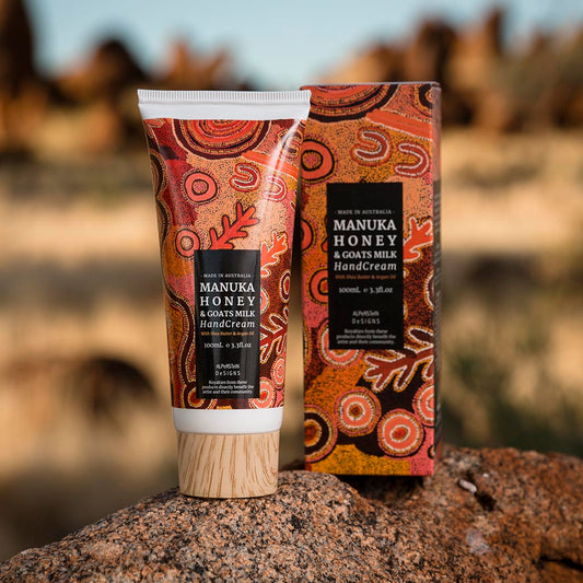 Manuka Honey & Goats Milk hand cream and packaging on a rock with a blurred natural background