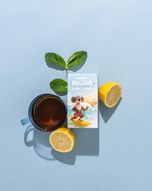 Tea cup with lemon slices, mint leaves, and a product box on a light blue background
