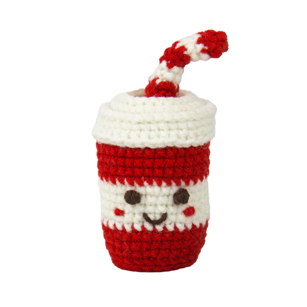 Crocheted cup with a face and red lid on a white background