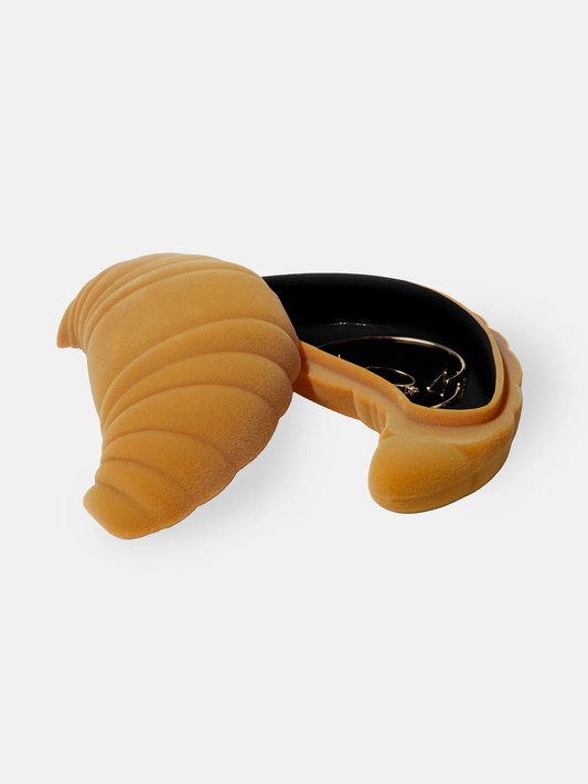Yellow croissant-shaped jewellery storage with a black interior on a white background
