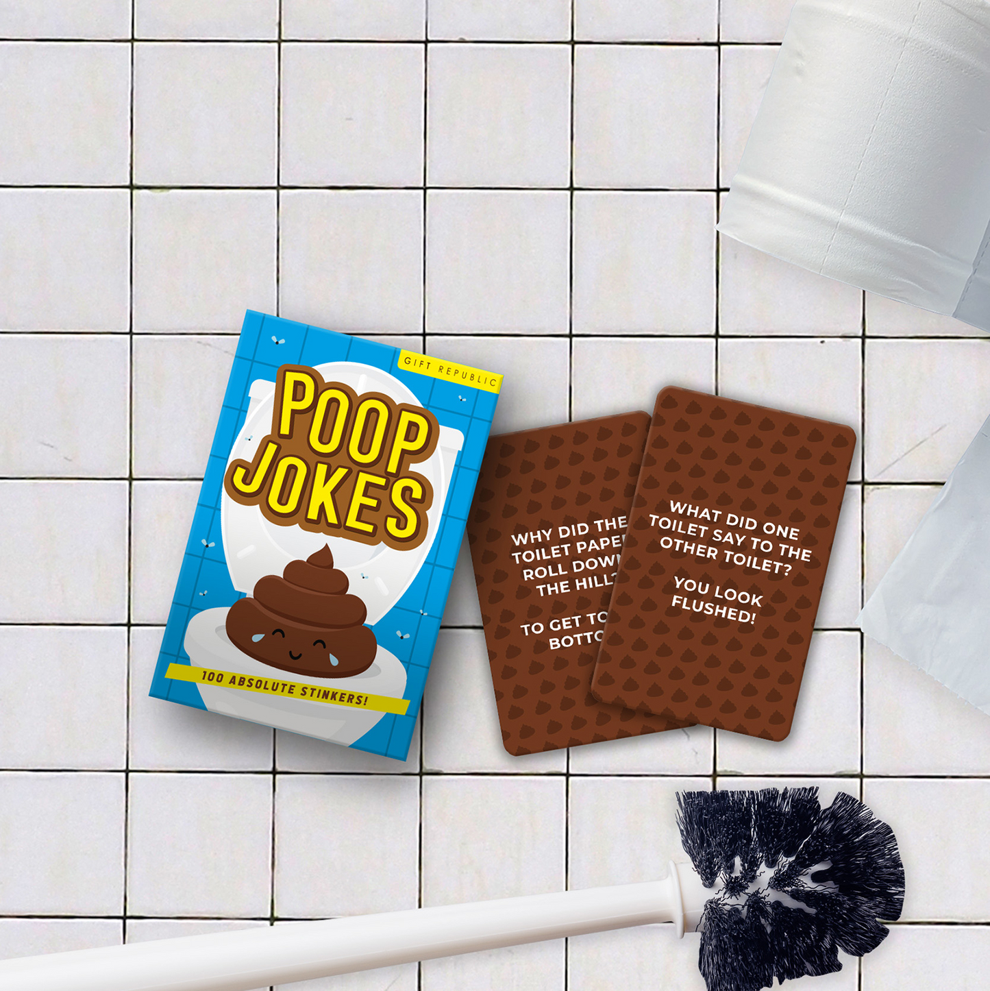 Book titled 'Poop Jokes' on a tiled bathroom floor with a toilet brush.