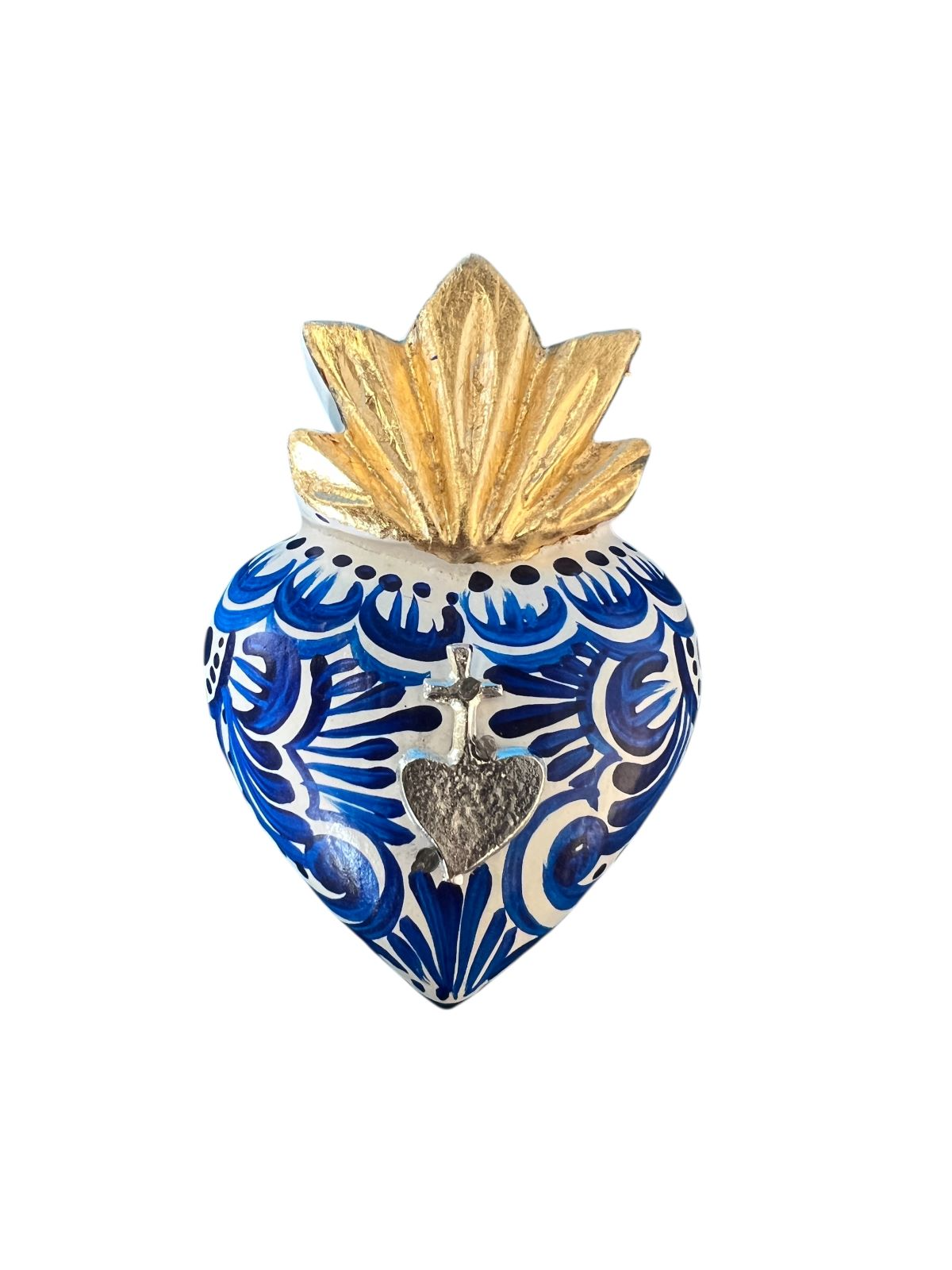 Decorative handmade Mexican wall, wooden heart-shaped ornament with blue patterns, gold top, and silver heart charm on a white background.