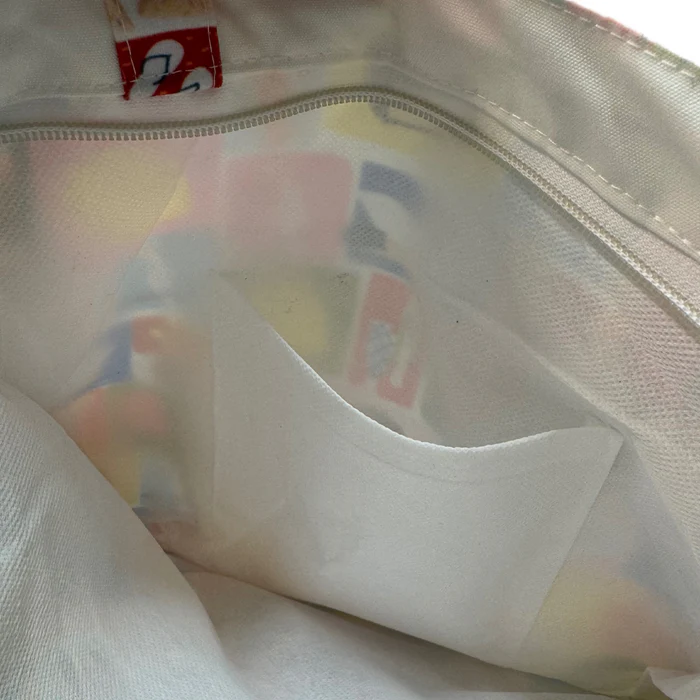 Close-up of a inside pocket of tote bag with white lining inside.