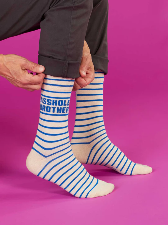 Person wearing blue and white striped socks with text on a pink background