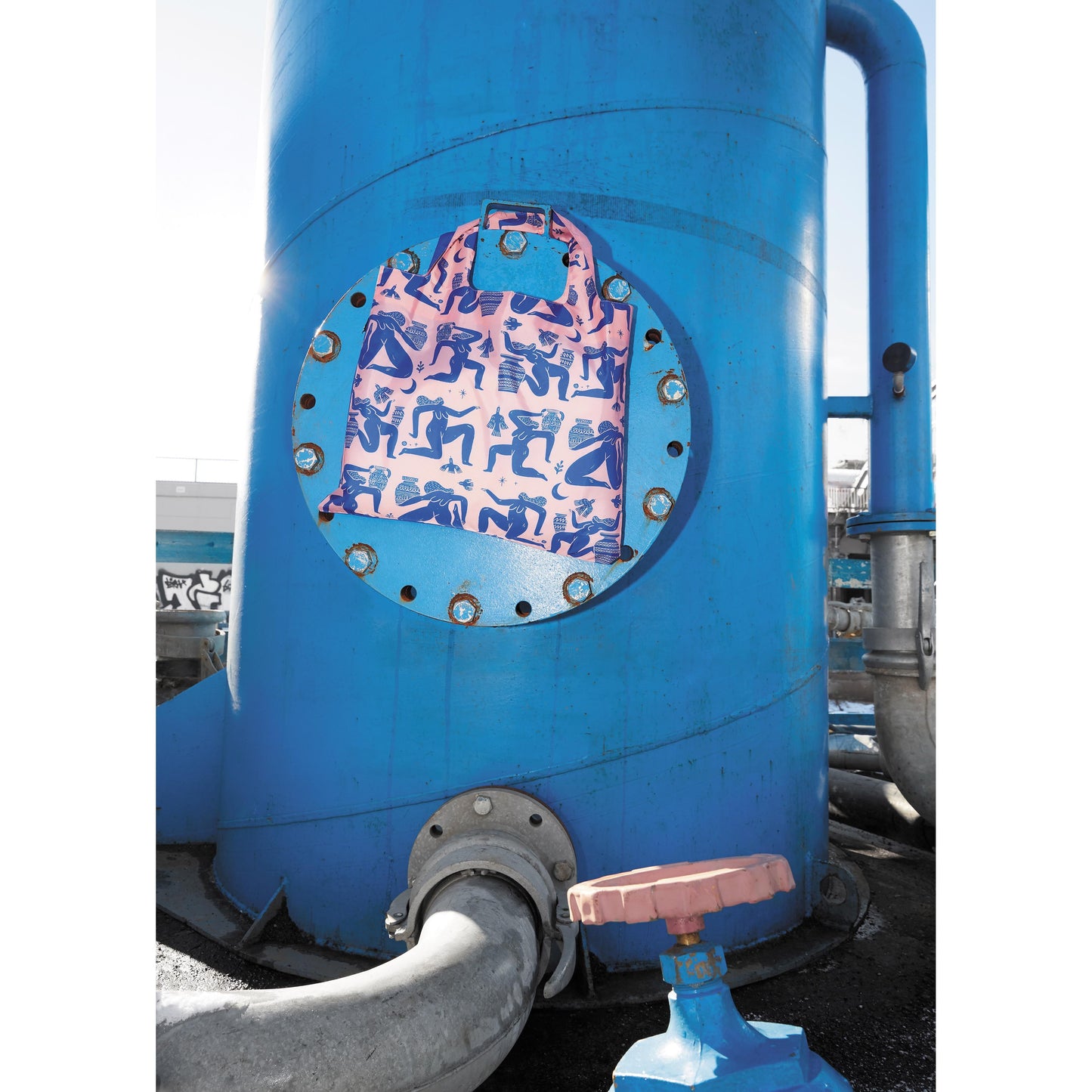 Blue cylindrical tank with a pink and blue patterned patch on a white background
