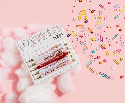 Set of pens in a box labeled 'Nurses' with colorful paper clips on a pink background