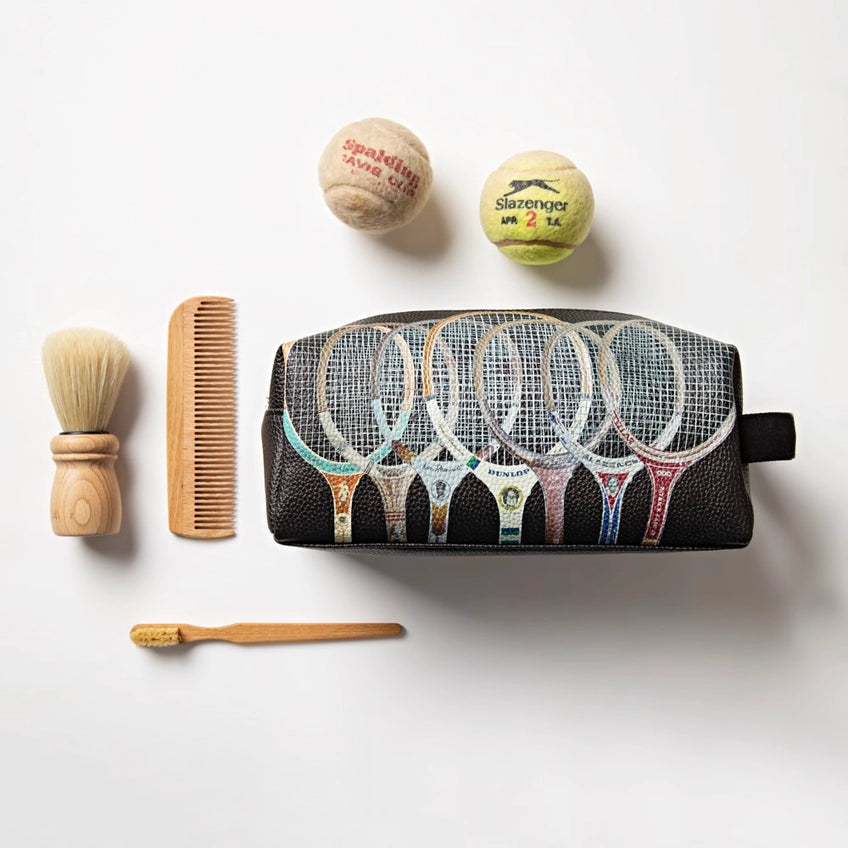 Cosmetic bag with tennis racket design, brush, comb, and balls on a white background