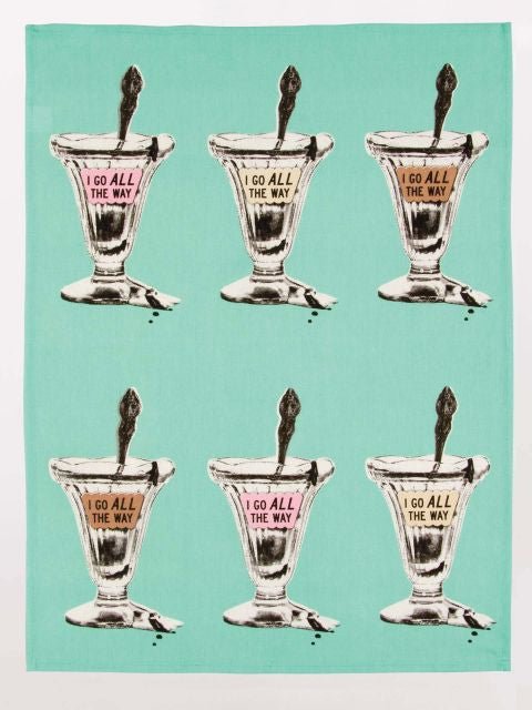 A blue tea towel with six recurring sundae glasses with coloured text boxes, each with the saying, "I go all the way". The background is white.