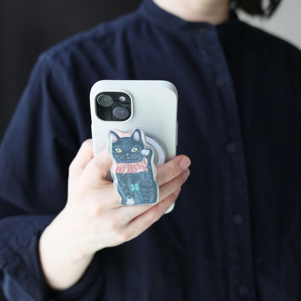 Person holding a phone with a cat-themed case against a dark background