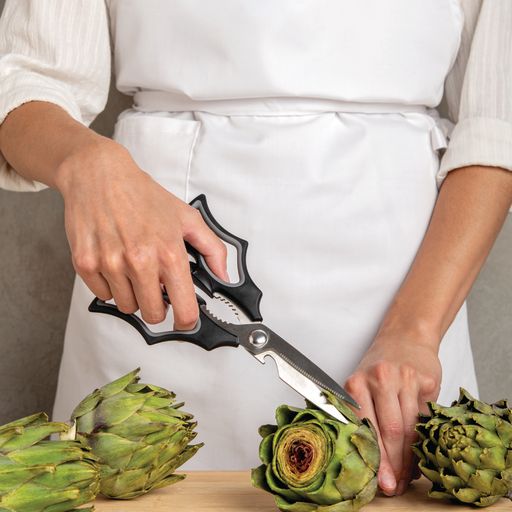 A person using the OTOTO Elizabat kitchen scissors and cutting artichokes