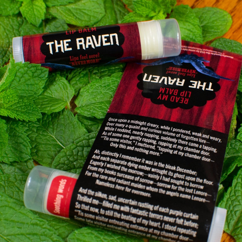 Lip balm with packaging titled 'The Raven' on a leafy background