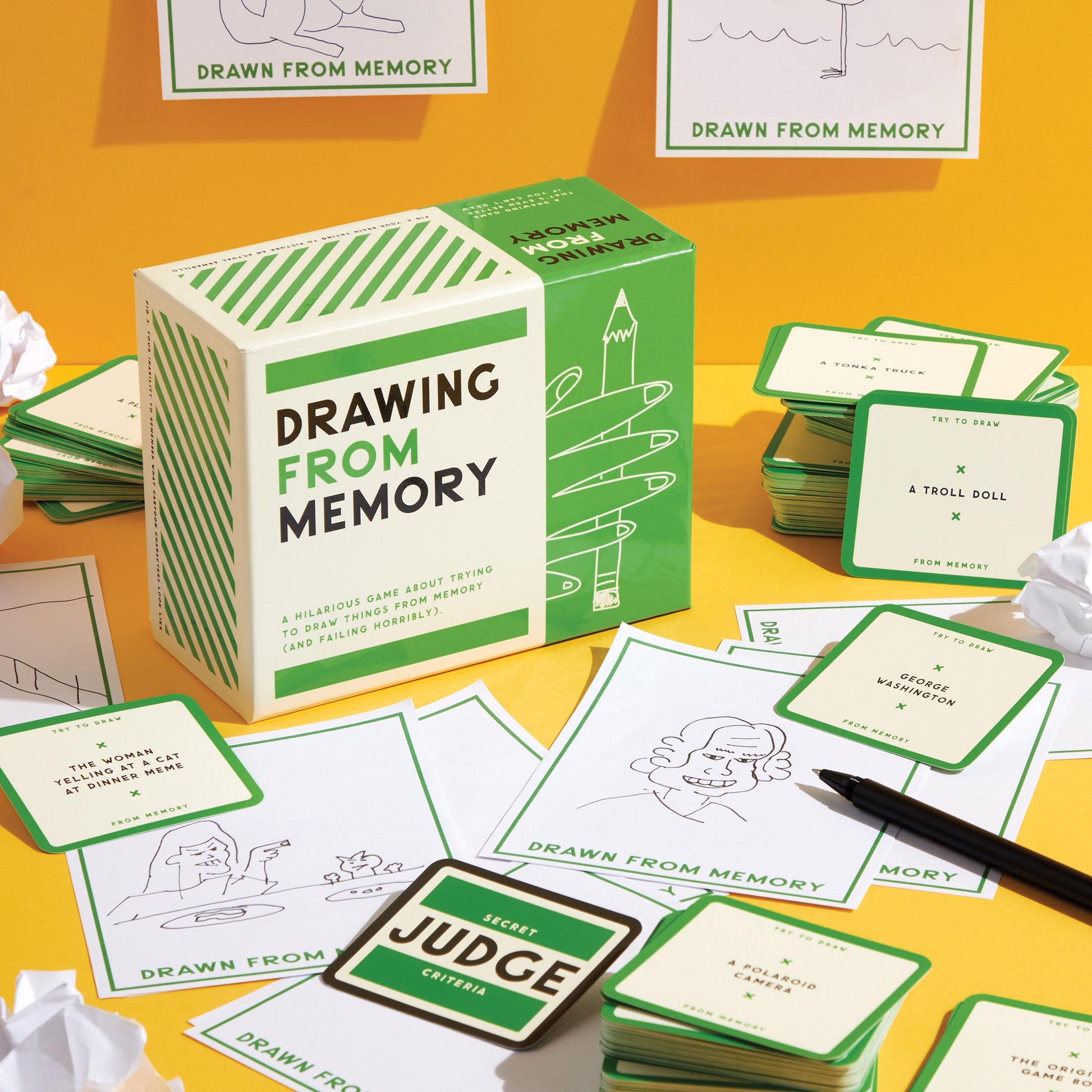 Drawing From Memory game with cards and box on a yellow surface