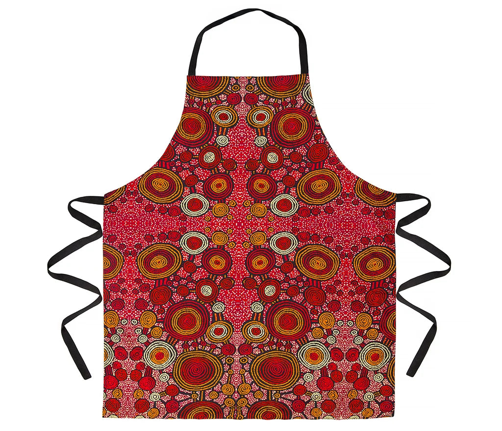 An indigenous art print apron by Teddy Gibson on a white background.