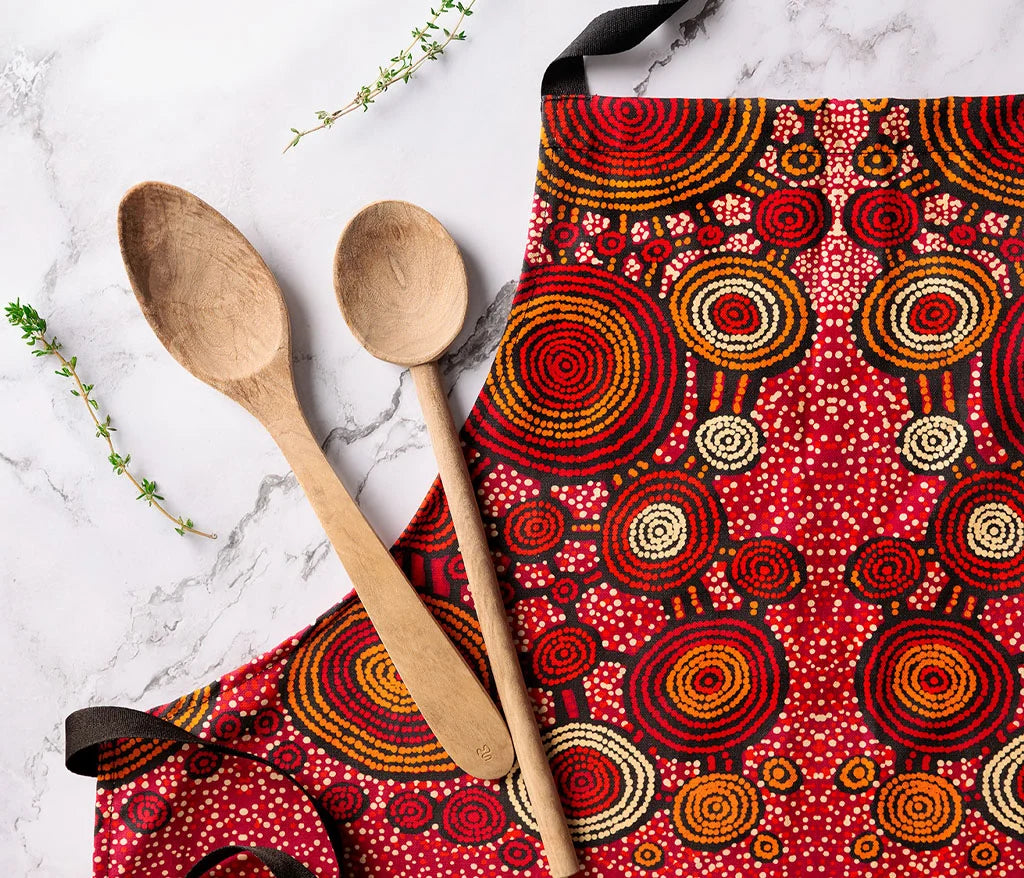 indigenous apron on a white marble table and two wooden spoons on the left side