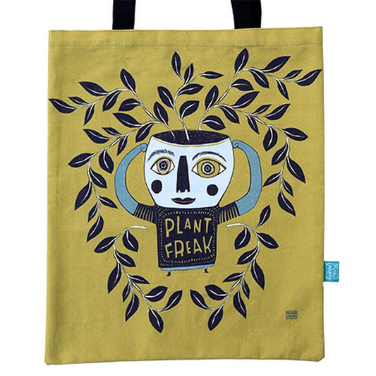 Tote bag with a graphic design of a face with leaves and 'Plant Freak' text on a mustard yellow background.