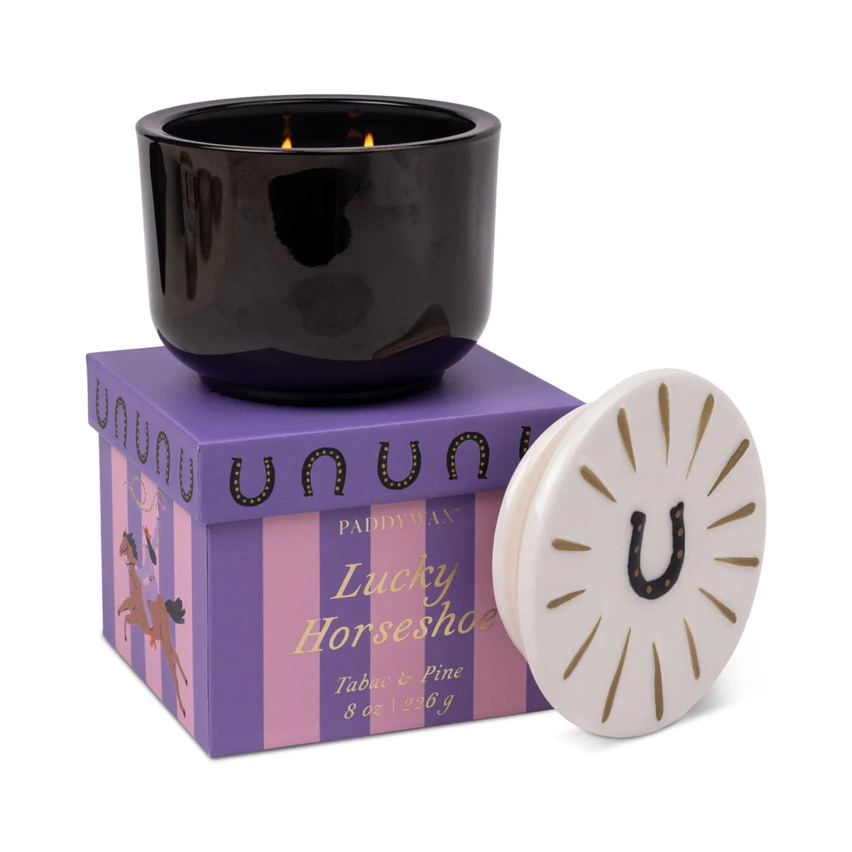 Black candle in a purple box with 'unown' branding, surrounded by decorative elements on a white background.