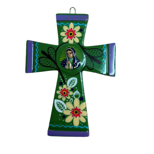 Green Mexican clay cross ornament with painterly floral design and a central motif of the Virgin Guadalupe.14.5cm x10 cm on a white background.