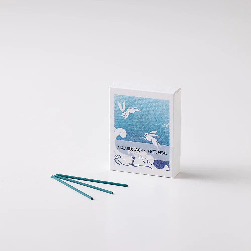 Incense packaging with blue design and three green incense sticks on a white background