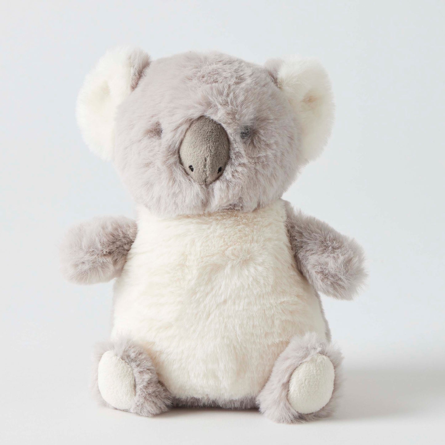 Plush toy koala and rattle on a white background
