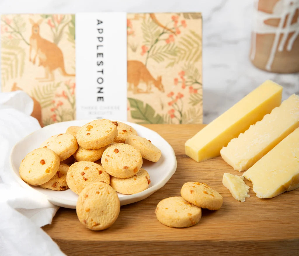 A plate of biscuits on a table spread with cheese and Applestone box in the background.
