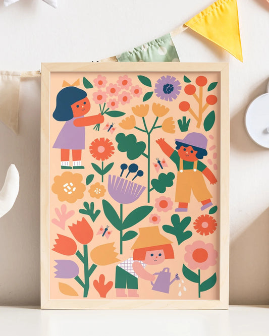 Framed children's painting with colorful flowers and children playing on a white surface.