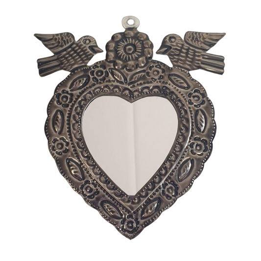 Decorative heart-shaped metal mini  wall mirror hanging with two birds and intricate patterns on a white background
