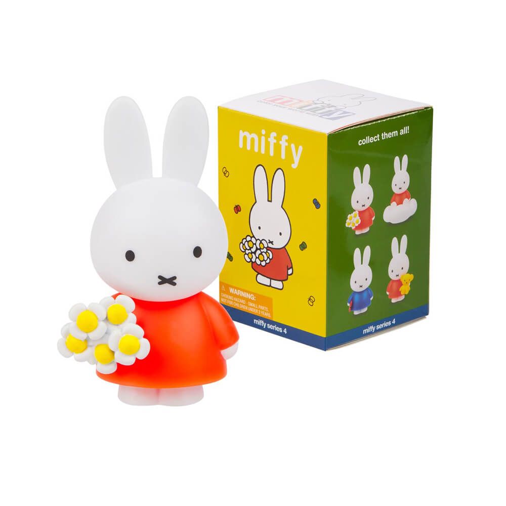 Miffy figurine with a red dress and flower bouquet next to its packaging on a white background