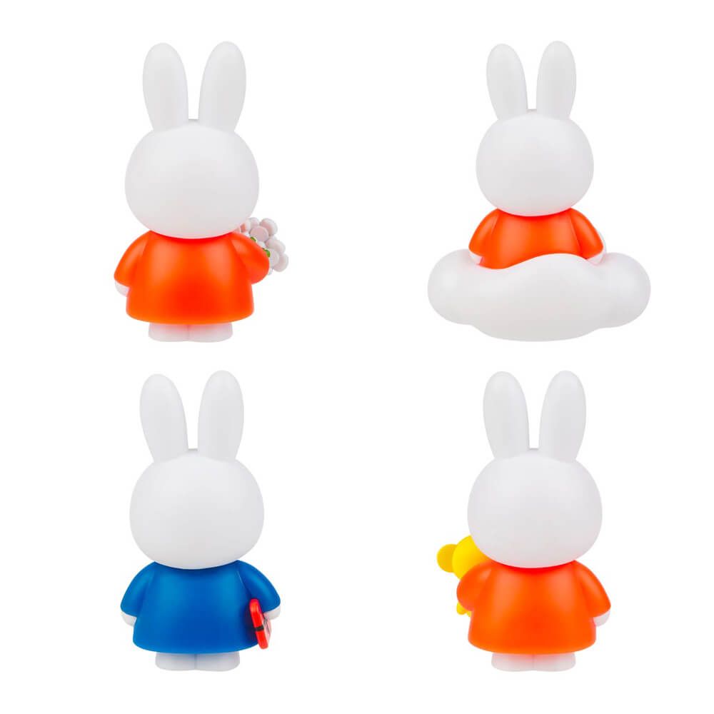 Four rabbit figurines wearing colorful dresses on a white background