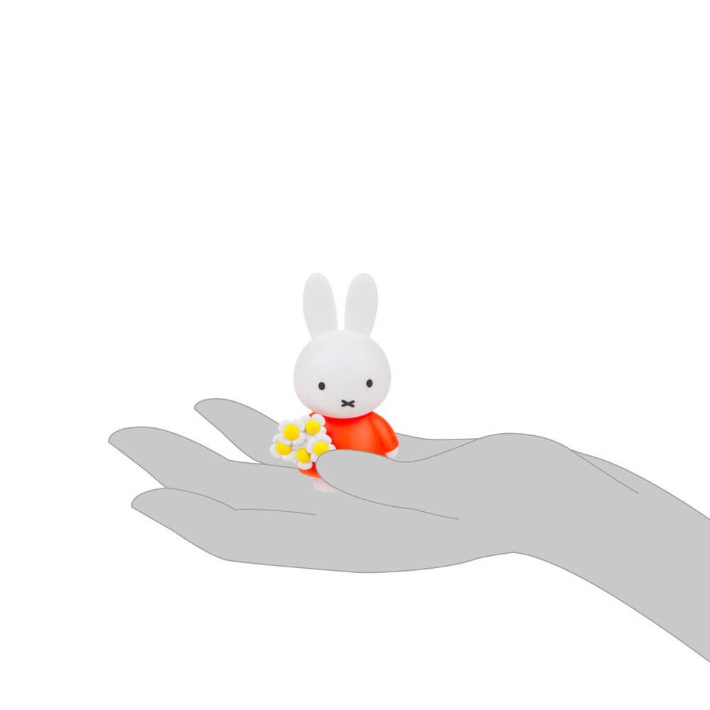 Small white rabbit figurine with a red outfit sitting on a hand