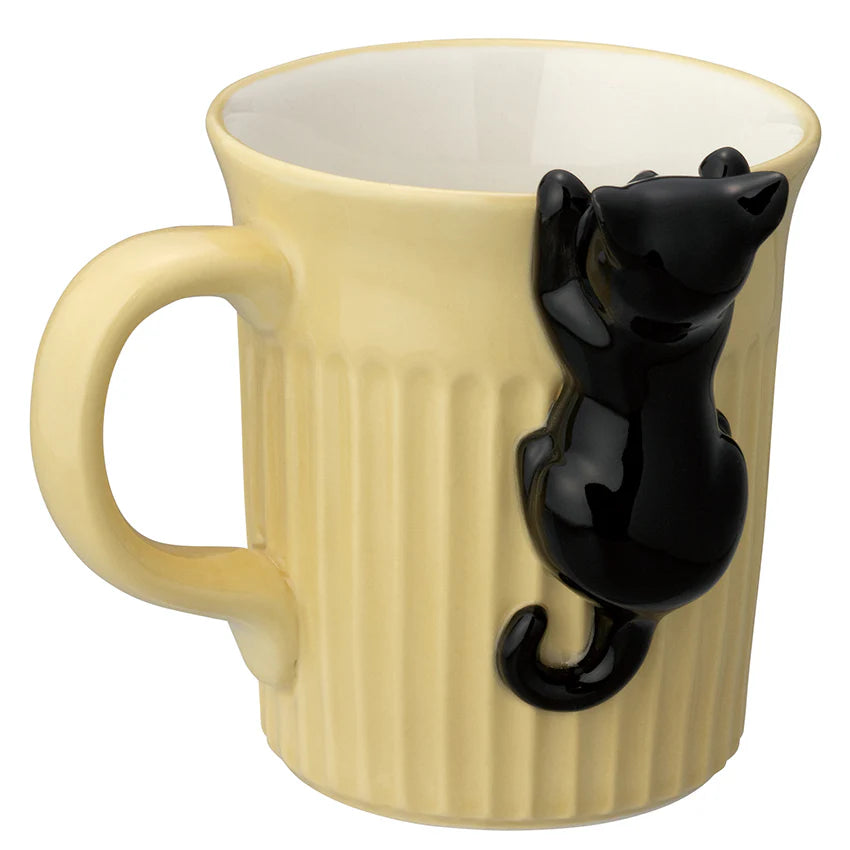 Beige mug with a black cat figurine on a white background