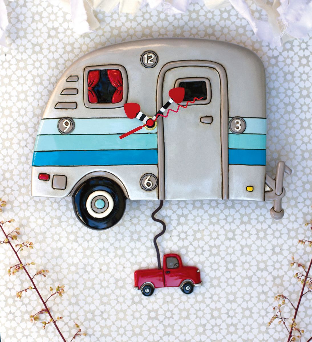 Decorative clock shaped like a camper with a red truck attached, on a textured white background.