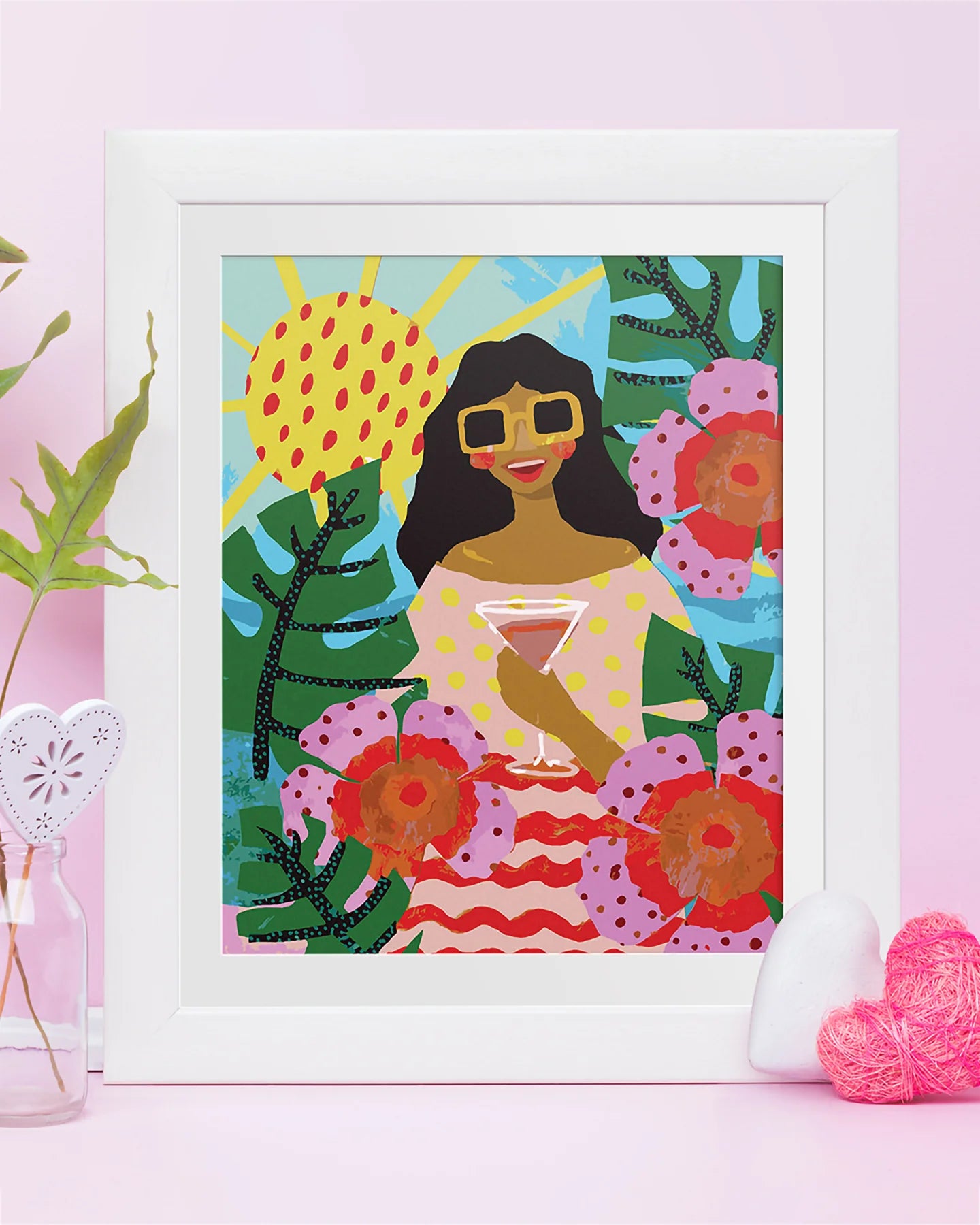Framed artwork of a woman surrounded by flowers and plants on a pink background