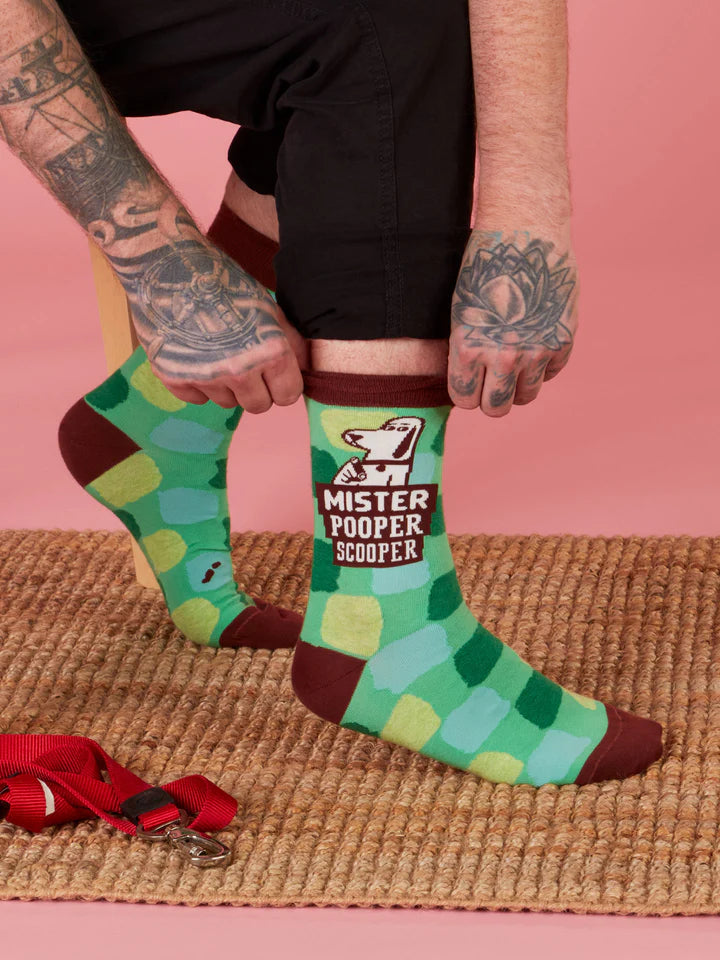Tattooed hands reaching down to pull up Mr.Pooper Scooper socks