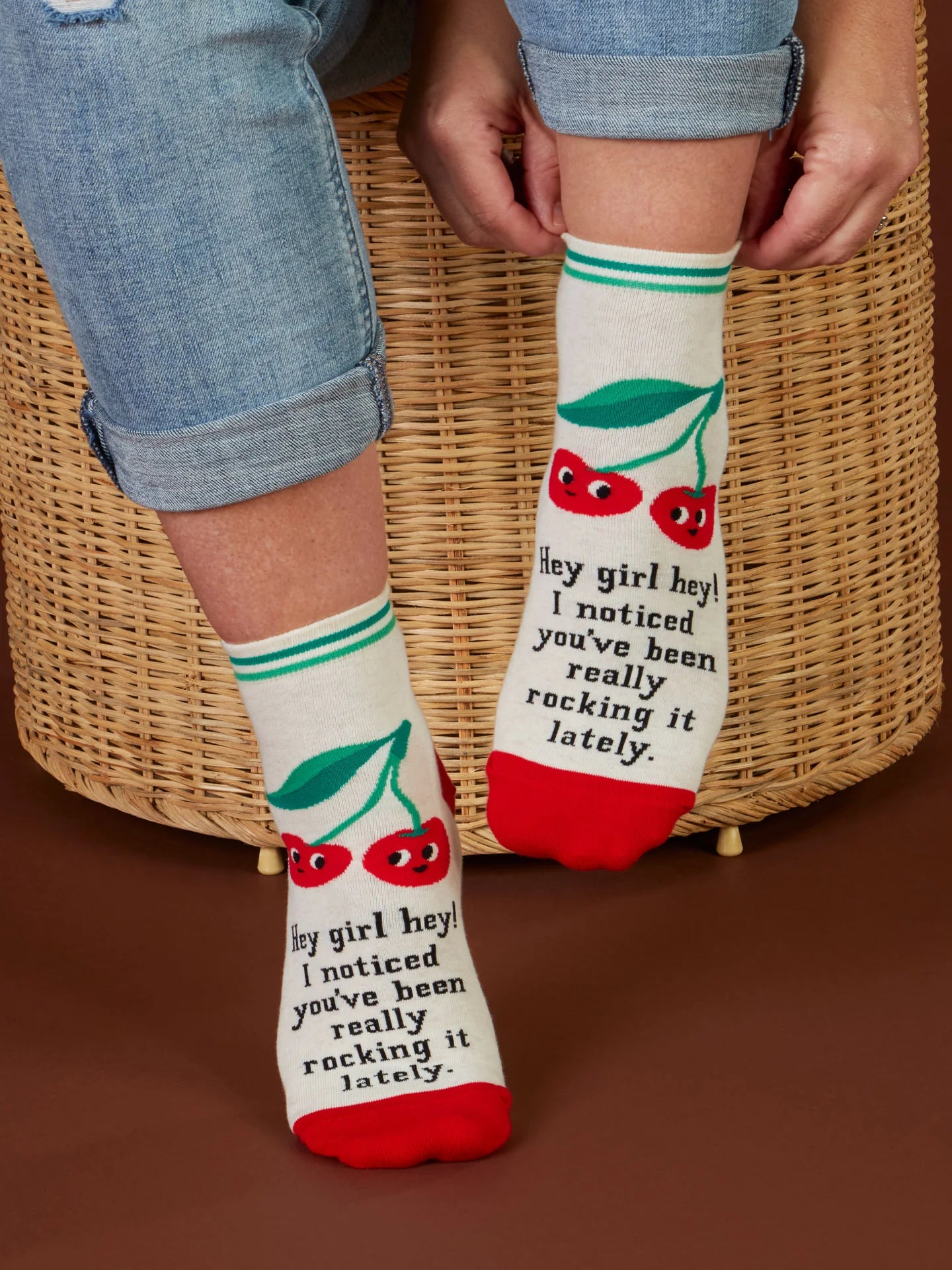 a person pulling up a pair of hey girl hey ankle socks.