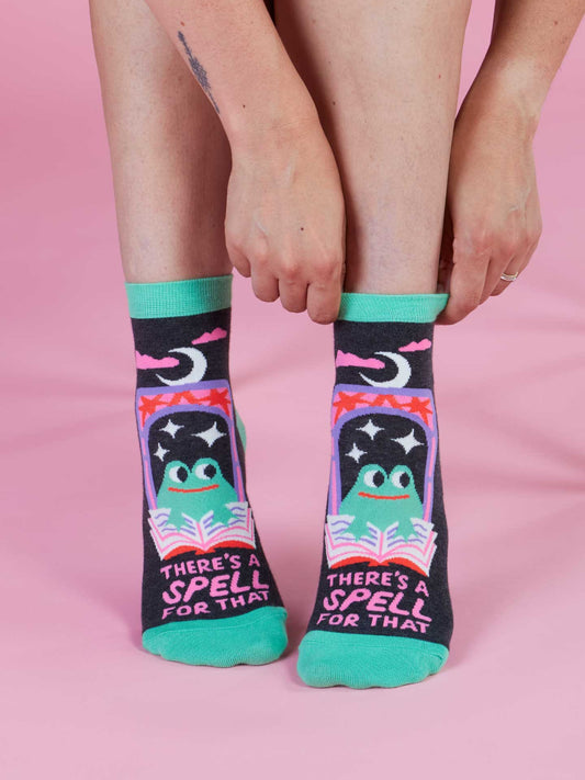 Person wearing socks with a colorful design and text on a pink background